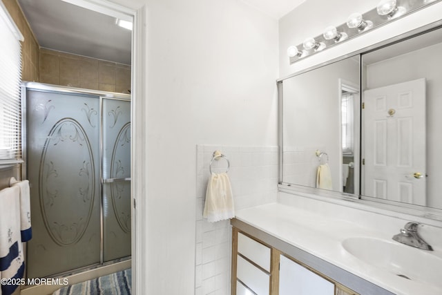 full bathroom featuring vanity, a shower with shower door, toilet, and tile walls