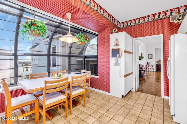 dining space featuring plenty of natural light and wallpapered walls