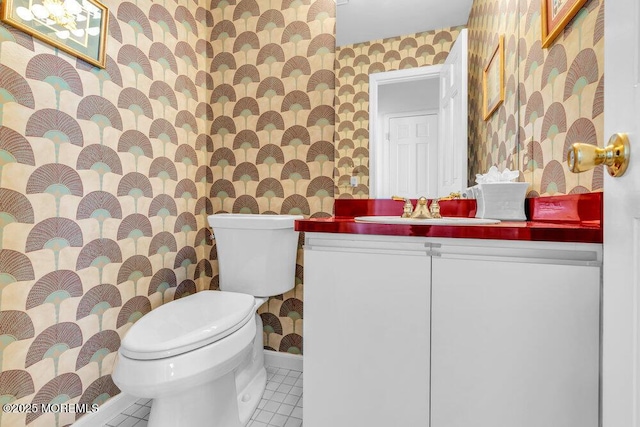bathroom featuring baseboards, tile patterned floors, toilet, and wallpapered walls