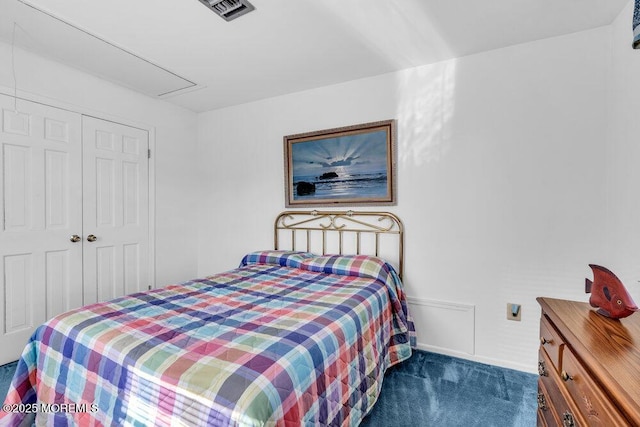 carpeted bedroom featuring a closet, baseboards, attic access, and visible vents