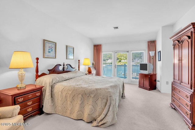 bedroom with access to outside, visible vents, and light colored carpet