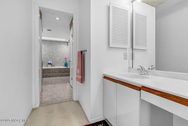 bathroom featuring vanity, baseboards, a bathing tub, and recessed lighting