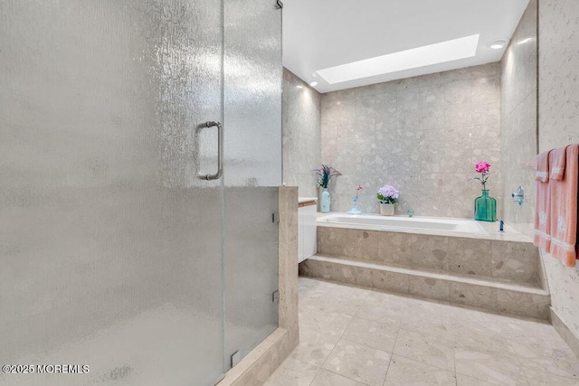 full bathroom featuring a skylight, tile walls, a shower stall, and a bath
