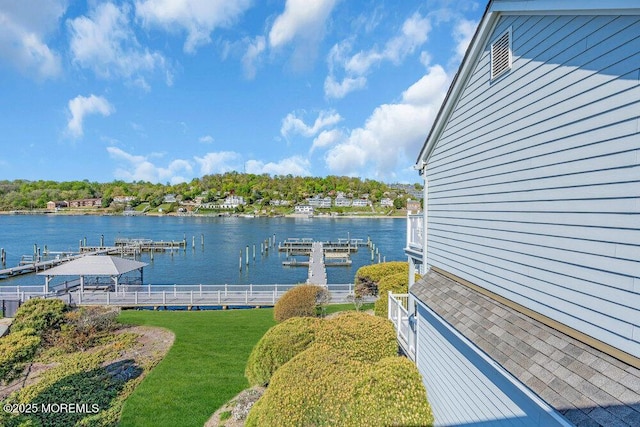 exterior space featuring a water view, fence, and a yard