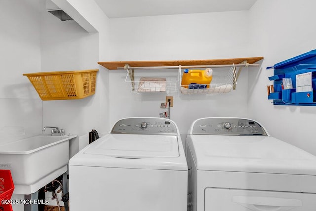 washroom with laundry area, a sink, and washer and clothes dryer