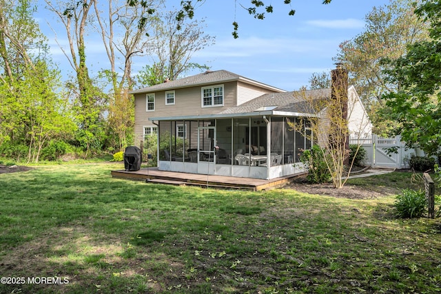 rear view of house featuring a sunroom, a gate, a yard, and a chimney