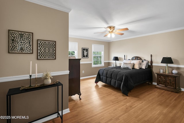 bedroom featuring baseboards, ornamental molding, a ceiling fan, and light wood-type flooring