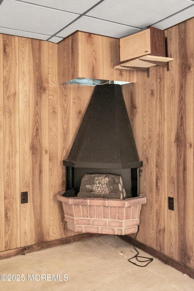 room details featuring a drop ceiling and wood walls