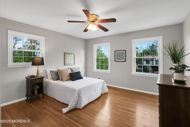 bedroom with baseboards, ceiling fan, and wood finished floors