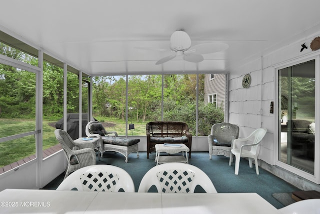 sunroom with plenty of natural light, a ceiling fan, and an outdoor living space