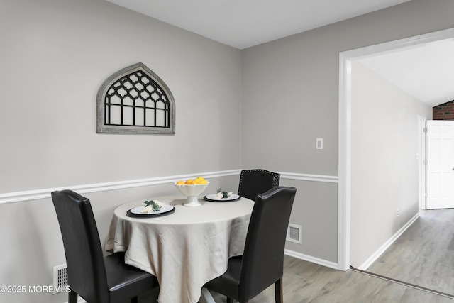 dining room with visible vents, baseboards, and wood finished floors