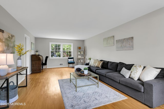 living room with baseboards, light wood-type flooring, and visible vents