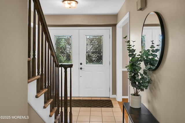 foyer featuring light tile patterned floors and stairway