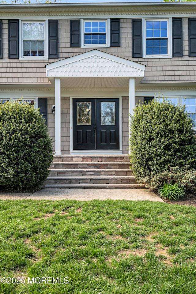 doorway to property featuring a lawn