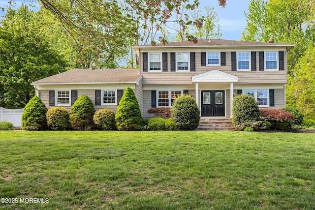colonial house with fence and a front lawn