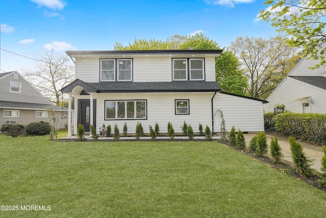 back of house with a yard and a shingled roof