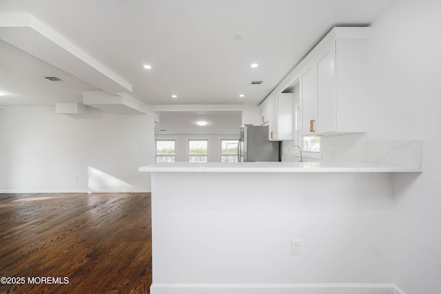 kitchen with dark wood-style floors, open floor plan, white cabinetry, and freestanding refrigerator
