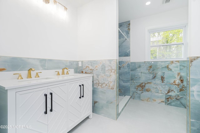 bathroom featuring a wainscoted wall, walk in shower, and a sink