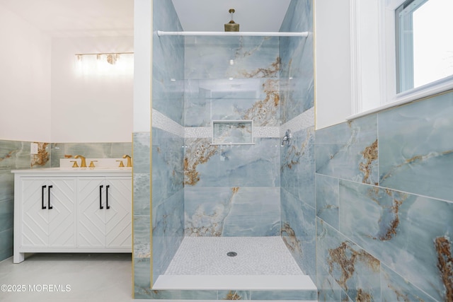 bathroom with vanity, a shower stall, and tile walls