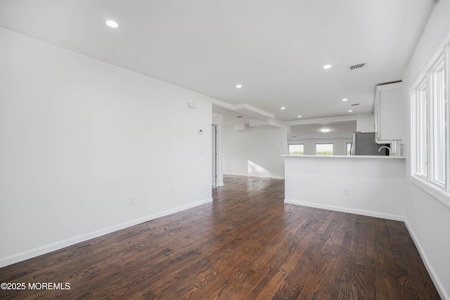 unfurnished living room with recessed lighting, visible vents, dark wood-style flooring, and baseboards