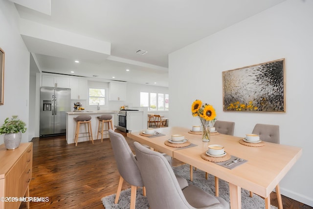 dining space with dark wood-style floors, visible vents, and recessed lighting
