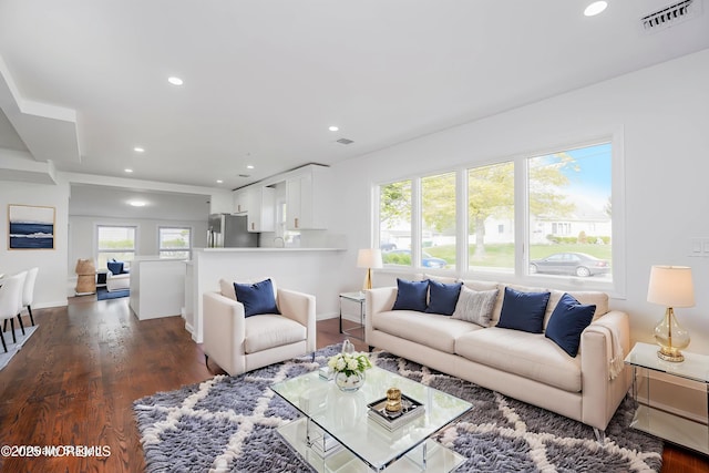living room featuring dark wood-style floors, visible vents, and recessed lighting
