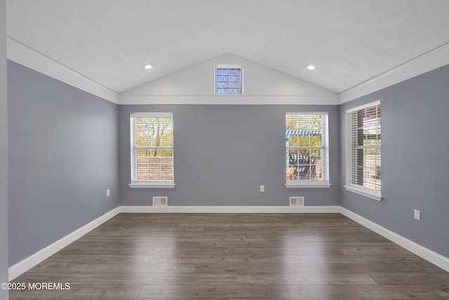 spare room featuring recessed lighting, vaulted ceiling, dark wood finished floors, and visible vents
