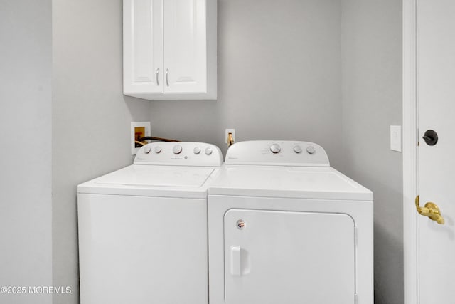 clothes washing area featuring cabinet space and washer and dryer