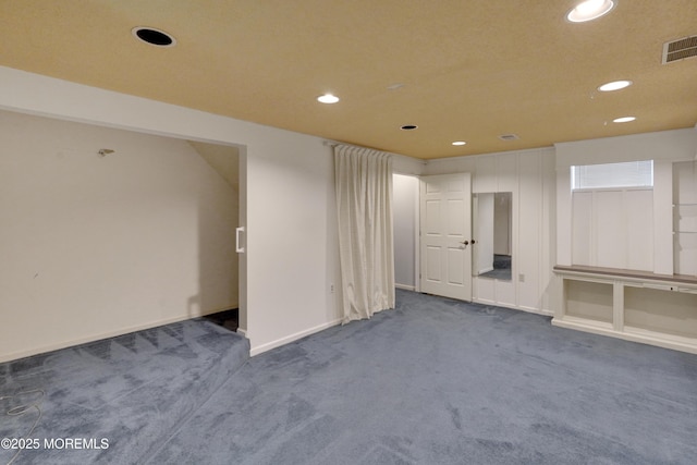 below grade area featuring recessed lighting, baseboards, visible vents, and dark colored carpet