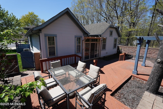 deck with a gate and outdoor dining space