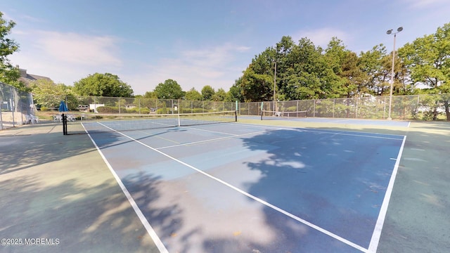 view of tennis court with fence