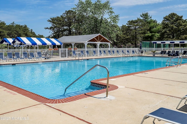pool featuring fence and a patio area