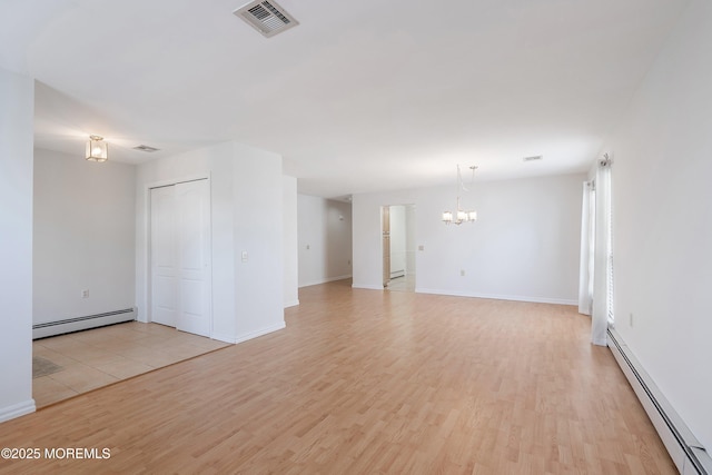 unfurnished living room featuring visible vents, light wood finished floors, a chandelier, and baseboard heating