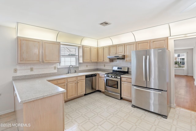 kitchen featuring visible vents, light brown cabinetry, appliances with stainless steel finishes, light countertops, and under cabinet range hood