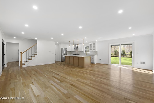 unfurnished living room with recessed lighting, stairs, light wood-style flooring, and visible vents