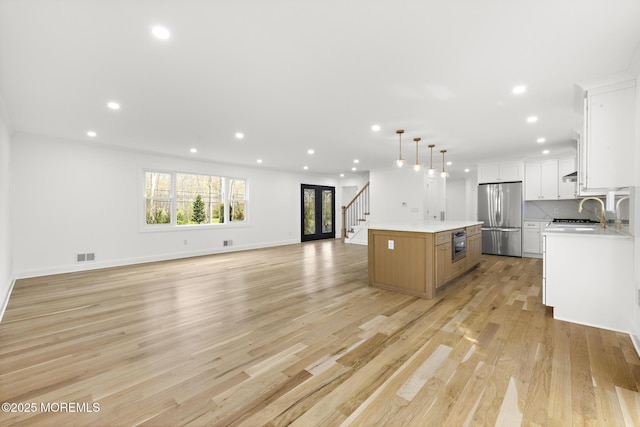 kitchen featuring a kitchen island, freestanding refrigerator, light wood finished floors, open floor plan, and recessed lighting