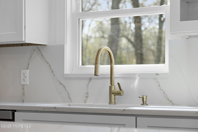interior details featuring light countertops, white cabinetry, and a sink