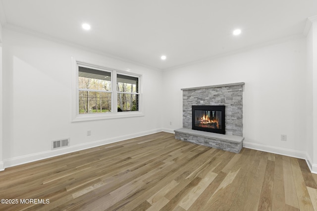 unfurnished living room featuring visible vents, crown molding, wood finished floors, and a fireplace
