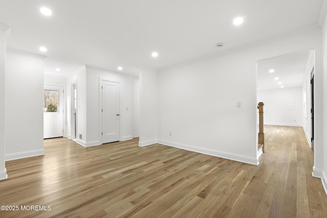 spare room featuring crown molding, recessed lighting, light wood finished floors, and baseboards