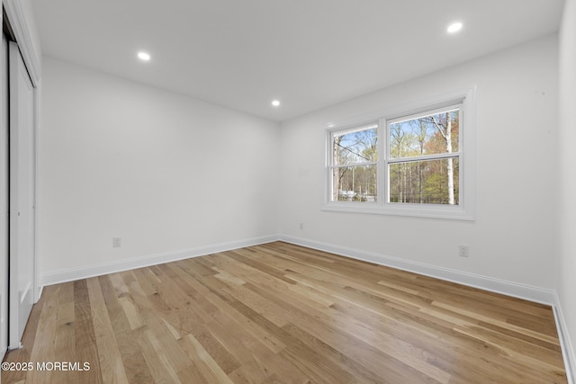 unfurnished bedroom with recessed lighting, baseboards, light wood finished floors, and a closet