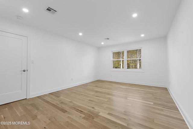 spare room featuring light wood-type flooring, recessed lighting, baseboards, and visible vents