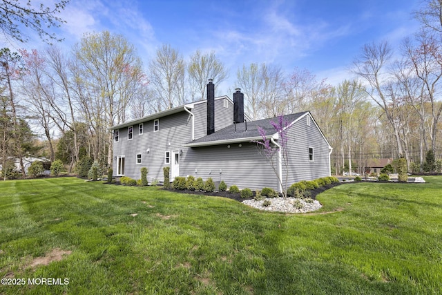 view of home's exterior featuring a lawn and a chimney