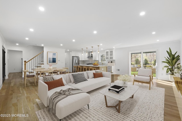 living room featuring stairway, light wood-type flooring, and recessed lighting