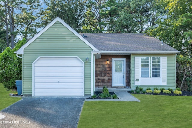 view of front of property featuring a front lawn, roof with shingles, a garage, and aphalt driveway