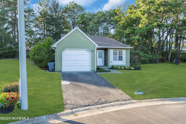 view of front of home with driveway, roof with shingles, a front yard, and an attached garage