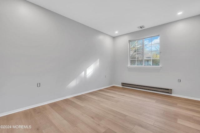 empty room with visible vents, light wood-style floors, baseboard heating, baseboards, and recessed lighting