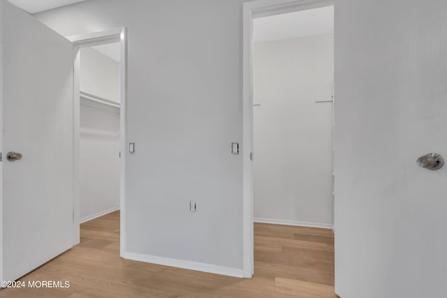 hallway with wood finished floors and baseboards
