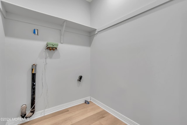 washroom featuring baseboards, light wood-type flooring, and laundry area