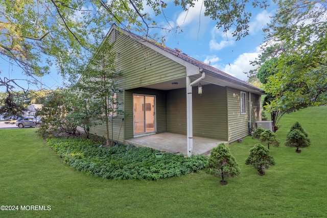 rear view of house featuring a lawn and a patio