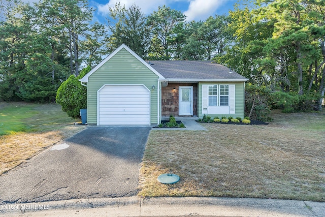 ranch-style house featuring a front yard, aphalt driveway, and a garage